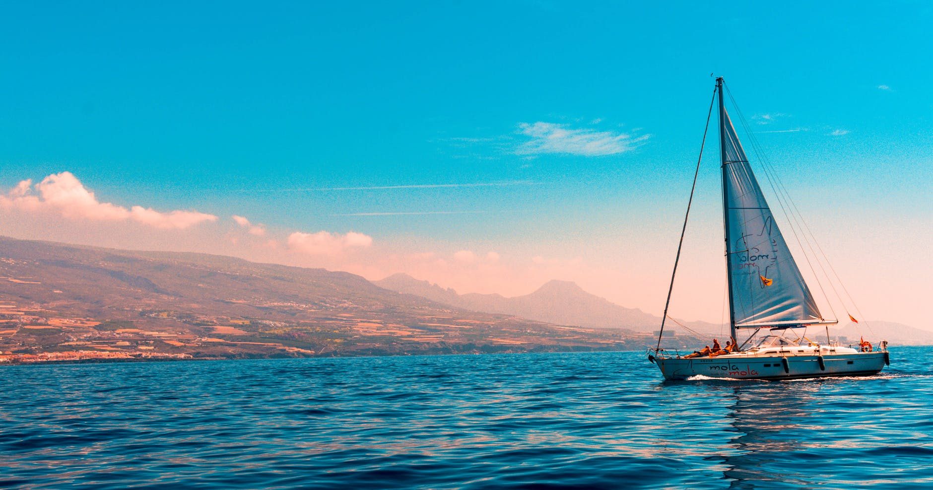sailboat sailing on water near island