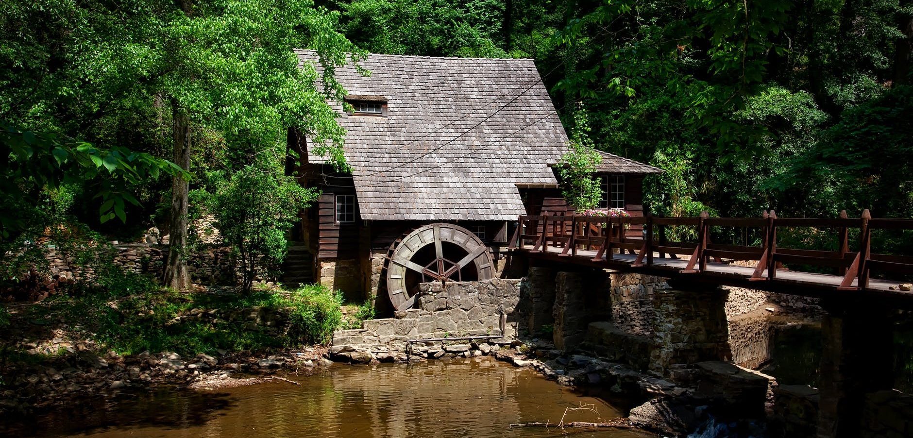 brown house near river trees and bridge