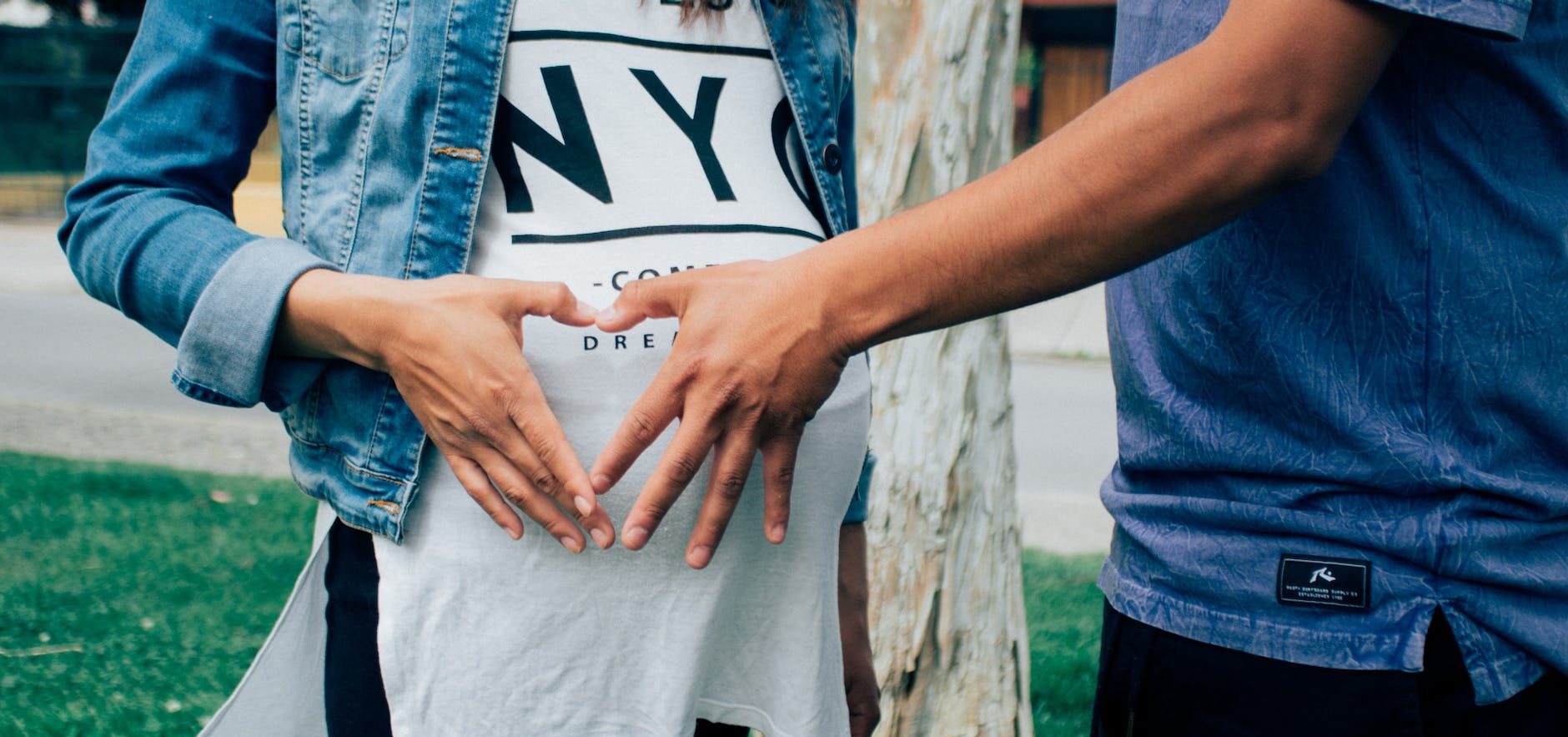 pregnant woman holding her tummy together with a man beside