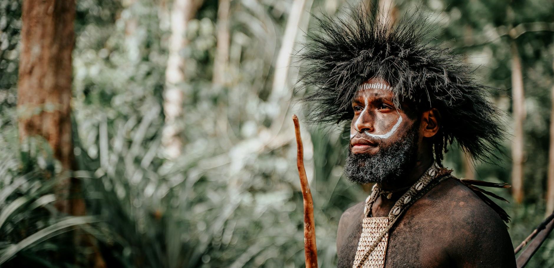 indigenous man with traditional face paint in jungle